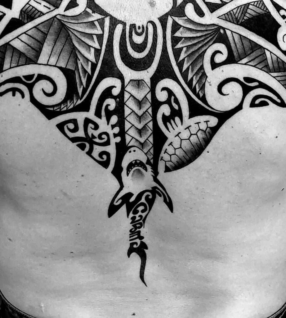 Polynézsky blackwork cez celý chrbát — slnečný disk medzi lopatkami, manta a žralok schádzajúci po chrbtici, ornament pokrýva chrbát až po kríže — detail 2