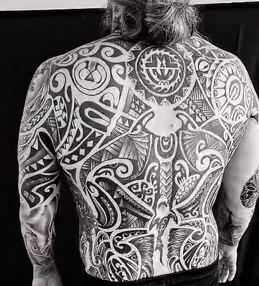 Polynézsky blackwork cez celý chrbát — slnečný disk medzi lopatkami, manta a žralok schádzajúci po chrbtici, ornament pokrýva chrbát až po kríže